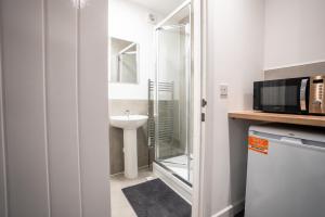 a small bathroom with a sink and a microwave at Seamflow Homes - Folkestone, near Eurotunnel - Channel Tunnel in Folkestone +47 photos
