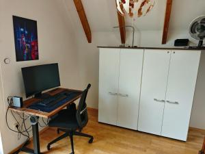 an office with a desk with a computer and a chair at Ferienhaus Ellmi in Kronach