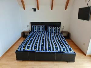 a bedroom with a black bed with a tv on the wall at Ferienhaus Ellmi in Kronach +13 photos