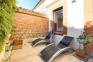 een terras met twee stoelen en een bakstenen muur bij NEW - Maison brique 4p - Côte Pavée coeur Toulouse in Toulouse