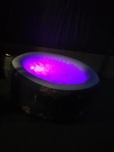 een jacuzzi gevuld met roze en paars water bij Cabalove in Quissac