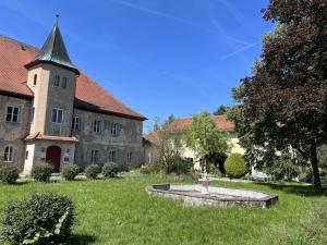 un vieux bâtiment avec une fontaine au milieu d'une cour dans l'établissement Schloss1611 B&B, à Erbendorf