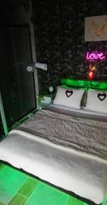 een slaapkamer met een bed met een bord dat liefde zegt bij Cabalove in Quissac