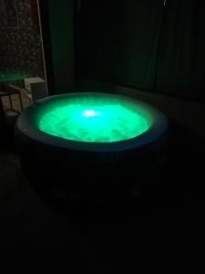 een groene jacuzzi in een donkere kamer bij Cabalove in Quissac