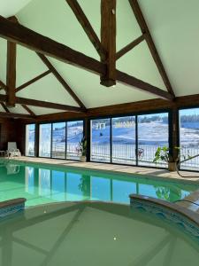 - une piscine dans une maison dotée d'une grande chambre avec fenêtres dans l'établissement Le Grand Connétable, à Châteauneuf-de-Randon