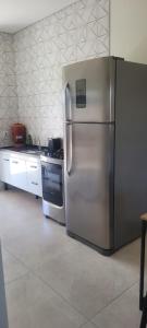 a kitchen with a stainless steel refrigerator and a stove at Montebelle casa2 in Porangaba +9 photos