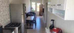 a kitchen with a stove and a table with chairs at Montebelle casa2 in Porangaba
