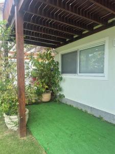 a patio with green grass and a pergola at Buzios Inn in Búzios
