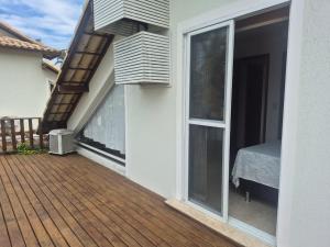 a balcony of a house with a bed and a window at Buzios Inn in Búzios