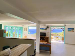 ein Wohnzimmer mit Blick auf das Meer in der Unterkunft Espace Harmonie Deshaies - Vue Mer & Piscine Panoramique in Deshaies
