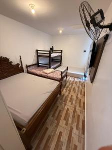 2 Betten in einem Zimmer mit Holzboden in der Unterkunft Refugio Paradisíaco 4 in Piçarras