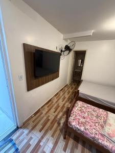 Zimmer mit einem Flachbild-TV an der Wand in der Unterkunft Refugio Paradisíaco 4 in Piçarras