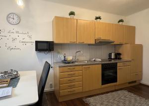 een keuken met houten kasten en een klok aan de muur bij Sankt Veit Apartment in Sankt Veit an der Glan +31 foto's