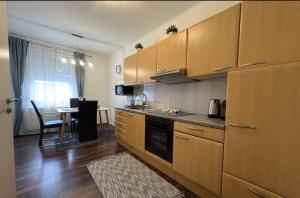 een keuken met houten kasten en een tafel in een kamer bij Sankt Veit Apartment in Sankt Veit an der Glan