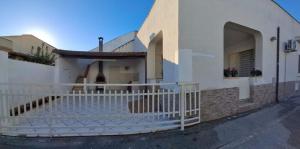 ein weißer Zaun vor einem Haus in der Unterkunft Villa Rosaria Triscina di Selinunte in Triscina