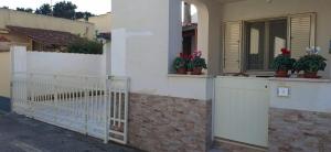 ein weißes Gebäude mit Topfpflanzen an einem Fenster in der Unterkunft Villa Rosaria Triscina di Selinunte in Triscina + 17 Fotos