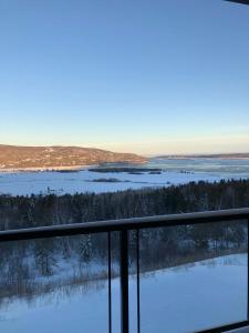 d'un balcon avec vue sur un champ enneigé. dans l'établissement 302 - Full View - See Look Admire - Pool & Gym, à Baie-Saint-Paul