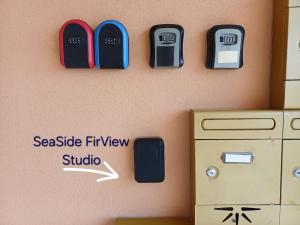 een muur met drie mobiele telefoons aan de muur bij SeaSide FirView Studio in Néa Khilí