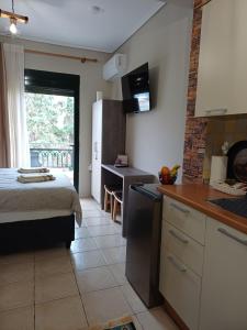 een slaapkamer met een bed en een keuken met een wastafel bij SeaSide FirView Studio in Néa Khilí