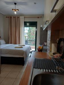 een slaapkamer met een bed en een keuken met een wastafel bij SeaSide FirView Studio in Néa Khilí