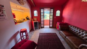 ein Wohnzimmer mit einem Sofa und einer roten Wand in der Unterkunft Nid aigle 3 Suites in Rio de Janeiro