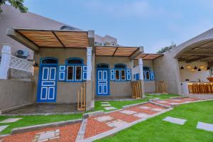 a house with blue doors and a yard at Arcadian Weligama in Weligama