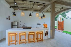 a kitchen with a island with stools and a counter top at Arcadian Weligama in Weligama +22 photos