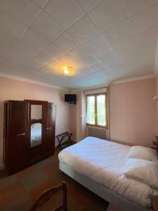 une chambre avec un grand lit et une fenêtre dans l'établissement Le Grand Connétable, à Châteauneuf-de-Randon