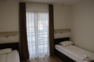 een slaapkamer met twee bedden en een groot raam bij Tumanski Konak, Natalije Dugošević 17 in Golubac