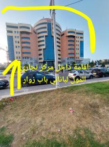 een bord voor een gebouw met een stad bij اقامة الجنينة in Kouba