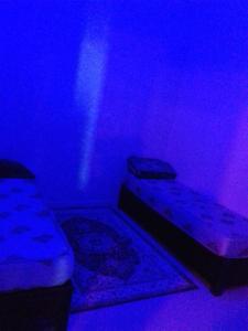 een slaapkamer met 2 bedden in een paarse kamer bij اقامة الجنينة in Kouba