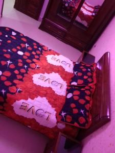 een slaapkamer met een bed met een deken en kussens bij اقامة الجنينة in Kouba +1 foto