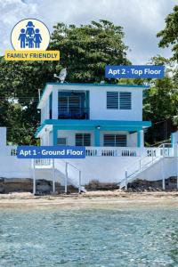 ein blau-weißes Haus neben dem Wasser in der Unterkunft Ocean Breeze Terrace 1st Floor Sleeps 6 Beach Walk 