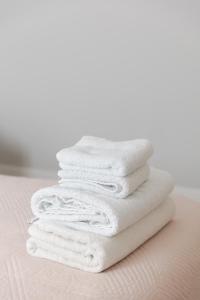 een stapel witte handdoeken zittend op een bed bij D&E Cozy Stay in Sauk