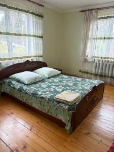 een slaapkamer met een bed in een kamer met ramen bij Karpatski Prostory in Slavske