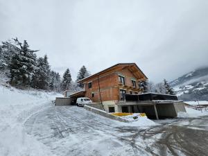een huis in de sneeuw op een besneeuwde weg bij Apartment Warscher in Ainet