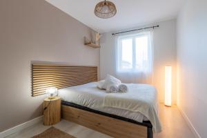 een slaapkamer met een bed met twee handdoeken erop bij Sleep & Cozy Disneyland in Coupvray