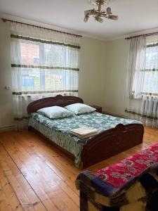 een slaapkamer met een bed in een kamer met ramen bij Karpatski Prostory in Slavske