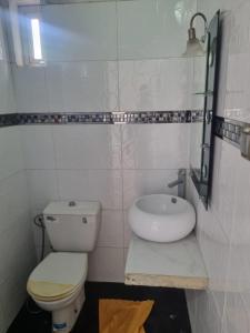 een witte badkamer met een toilet en een wastafel bij We'llcome home in Temara