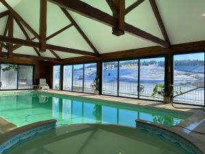 - une grande piscine dans une maison dotée de fenêtres dans l'établissement Le Grand Connétable, à Châteauneuf-de-Randon