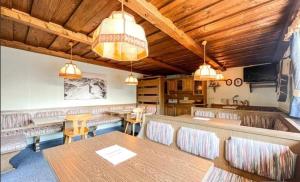 una sala da pranzo con tavoli, sedie e luci di Pension Panorama Warth a Lechleiten