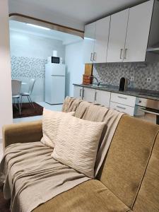 een bank in een woonkamer met een keuken bij ManelMar O Refúgio in Nazaré