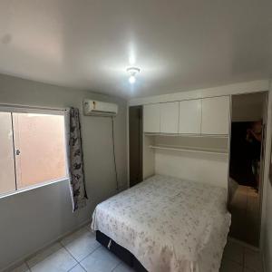 a small bedroom with a bed and a window at Aconchego Litorâneo 2 in Piçarras
