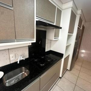a small kitchen with a sink and a stove at Aconchego Litorâneo 2 in Piçarras