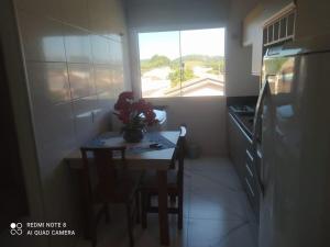a small kitchen with a table and a window at Aconchego Litorâneo 2 in Piçarras