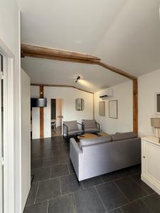 een woonkamer met een bank en een tafel bij Gîte Le Grand Landais - La Forge De Clermont in Clermont