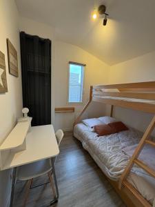 een slaapkamer met twee stapelbedden en een bureau bij Gîte Le Grand Landais - La Forge De Clermont in Clermont