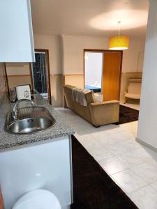 een keuken met een spoelbak en een woonkamer bij ManelMar O Refúgio in Nazaré