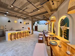 a restaurant with wooden tables and a kitchen with a counter at Arcadian Weligama in Weligama