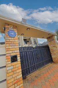 ein Haus mit einem schwarzen Tor mit einem Schild drauf in der Unterkunft Homes by her in Entebbe